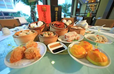 a table with plates of food on a table at Ramada Plaza by Wyndham Bangkok Menam Riverside in Bangkok