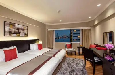 a hotel room with a large bed and a window at Ramada Plaza by Wyndham Bangkok Menam Riverside in Bangkok
