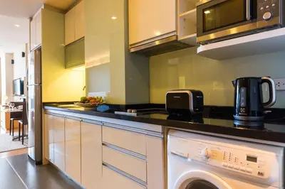 a kitchen with a washer and dryer on a counter at Somerset Sukhumvit Thonglor Bangkok in Bangkok