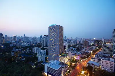 a city skyline at night with a tall building at Somerset Sukhumvit Thonglor Bangkok in Bangkok