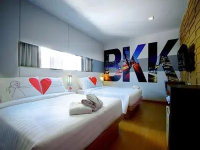 two beds in a hotel room with posters on the wall at Ds67 Suites in Bangkok