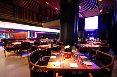 a dining room with wooden tables and chairs at JC Kevin Sathorn Bangkok Hotel in Bangkok