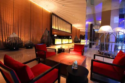 a restaurant with red chairs and a wooden table at JC Kevin Sathorn Bangkok Hotel in Bangkok