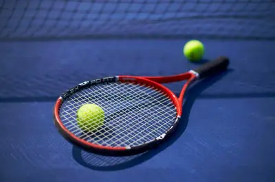 a tennis racket and a tennis ball on a court at JC Kevin Sathorn Bangkok Hotel in Bangkok