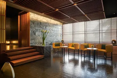 a restaurant with yellow chairs and tables in a room at JC Kevin Sathorn Bangkok Hotel in Bangkok