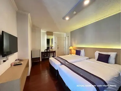 a hotel room with two beds and a flat screen tv at Collection O The Step Sathorn in Bangkok