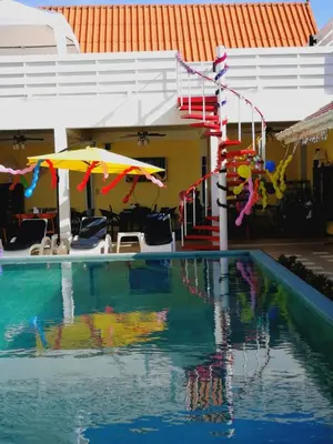 a swimming pool with umbrellas and a house at Barefeet Naturist Resort in Bangkok