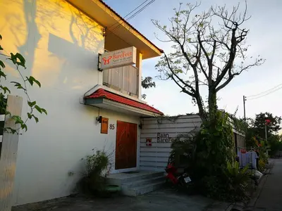 a white building with a sign for a restaurant at Barefeet Naturist Resort in Bangkok