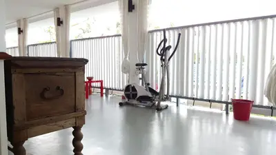 a room with a gym with a treadmill and an exercise bike at Barefeet Naturist Resort in Bangkok