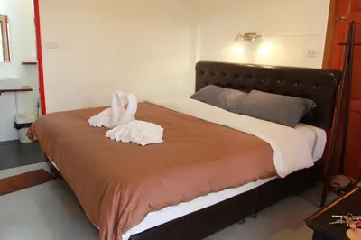 a bed with two towel animals sitting on it at Barefeet Naturist Resort in Bangkok