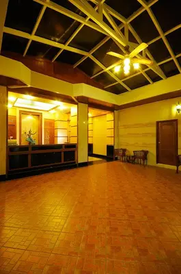 a large empty room with a wooden floor and a stage at Violet Tower at Khaosan Palace in Bangkok