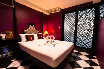 a bedroom with a bed with two swans on it at Violet Tower at Khaosan Palace in Bangkok