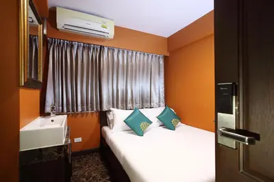 a small bedroom with two beds and a sink at Violet Tower at Khaosan Palace in Bangkok