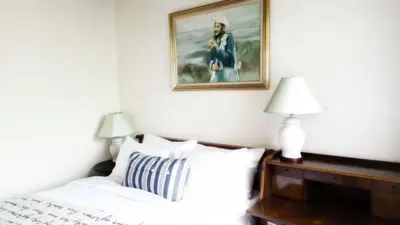 a bedroom with a bed and a painting on the wall at Villa Mungkala in Bangkok