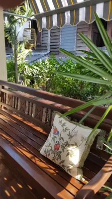 a pillow is sitting on a wooden bench at Villa Mungkala in Bangkok