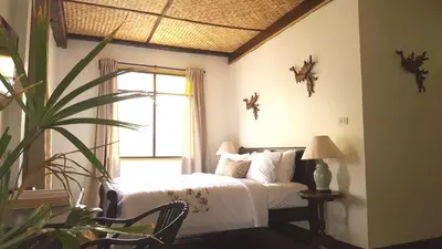 a bedroom with a bed and a window and a plant at Villa Mungkala in Bangkok
