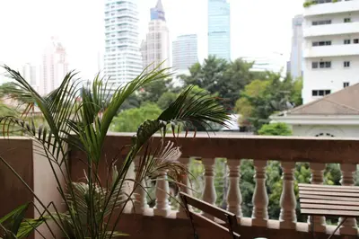 a balcony with a bench and a view of a city at Aster 9 House in Bangkok