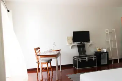 a room with a desk and a tv and a table at Aster 9 House in Bangkok
