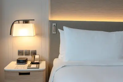 a bedroom with a bed and a phone on a night stand at Marriott Executive Apartments Bangkok, Sukhumvit 101 in Bangkok