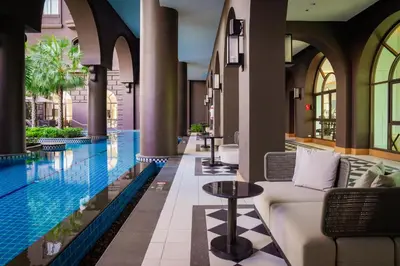 a hotel lobby with a pool and a couch at Marriott Executive Apartments Bangkok, Sukhumvit 101 in Bangkok