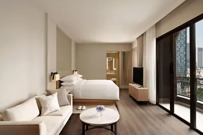 a hotel room with a bed and a couch at Marriott Executive Apartments Bangkok, Sukhumvit 101 in Bangkok