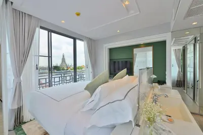 a living room with a white couch and large windows at Riva Arun Bangkok in Bangkok
