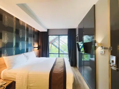 a hotel room with a bed and a window at Aspira Sukhumvit in Bangkok