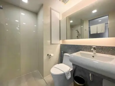 a bathroom with a sink and a toilet and a mirror at Aspira Sukhumvit in Bangkok