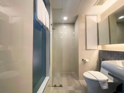 a bathroom with a shower and a toilet and a sink at Aspira Sukhumvit in Bangkok