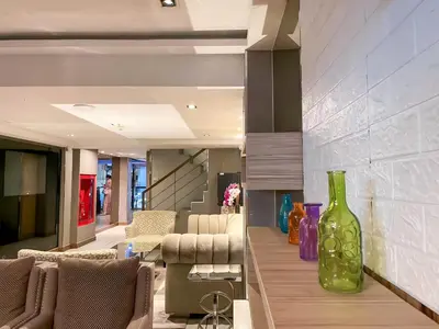 a living room with a large green vase on the wall at Aspira Sukhumvit in Bangkok
