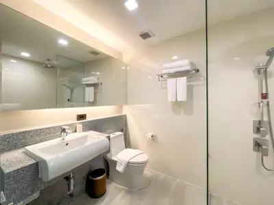 a bathroom with a sink and a toilet and a mirror at Aspira Sukhumvit in Bangkok