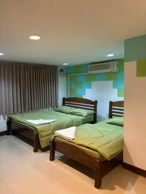 two beds sitting in a room with green at Alsana Hotel in Bangkok