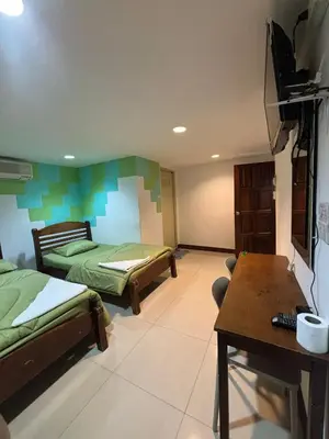 a room with two beds and a table in it at Alsana Hotel in Bangkok