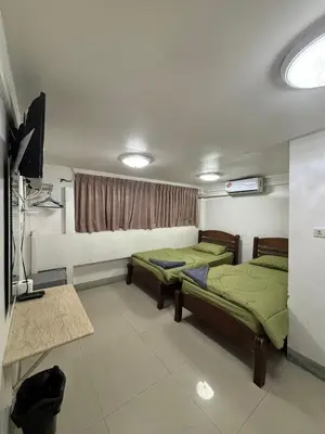 a room with two beds and a television in it at Alsana Hotel in Bangkok