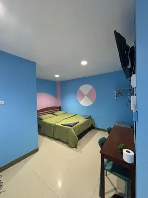 a bedroom with a green bed and a blue wall at Alsana Hotel in Bangkok