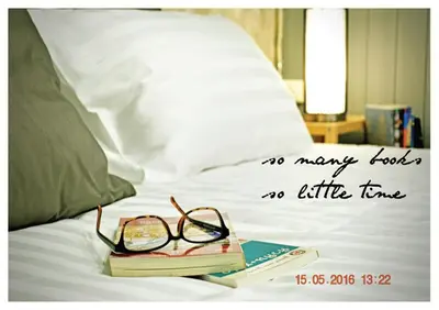 a pair of glasses sitting on a book on a bed at GOODFELLAS THONG LO HOSTEL #No check in after 5pm - Check in time needed# in Bangkok