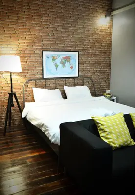 a bedroom with a bed and a brick wall at GOODFELLAS THONG LO HOSTEL #No check in after 5pm - Check in time needed# in Bangkok