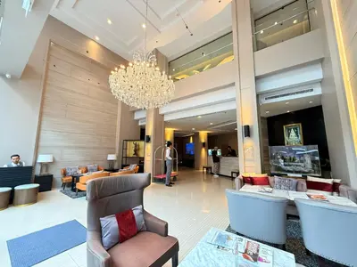 a lobby of a hotel with a chandelier at Civic Horizon Hotel & Residence in Bangkok