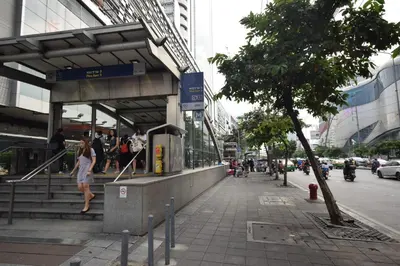 a woman walking down a sidewalk next to a building at Blissotel Ratchada in Bangkok