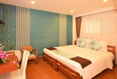 a bedroom with a bed and a desk and a room at Blissotel Ratchada in Bangkok