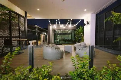 a lobby with two white chairs and a building at Kokotel Bangkok Sukhumvit 50 in Bangkok