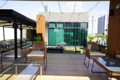 a patio with chairs and tables on a building at Kokotel Bangkok Sukhumvit 50 in Bangkok