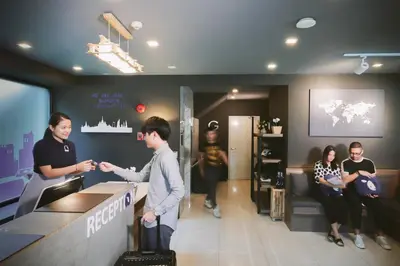 a man and a woman standing at a counter at Kokotel Bangkok Sukhumvit 50 in Bangkok