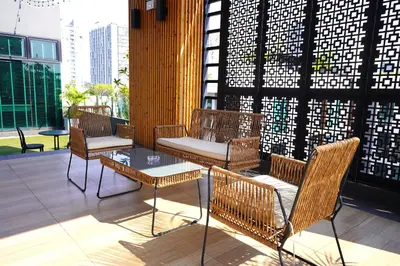 a patio with chairs and a table on a building at Kokotel Bangkok Sukhumvit 50 in Bangkok