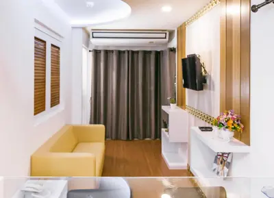 a living room with a yellow chair and a television at Sunset Residence Pinklao in Bangkok