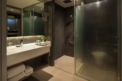 a bathroom with a sink and a shower at Grand 5 Hotel & Plaza Sukhumvit Bangkok in Bangkok