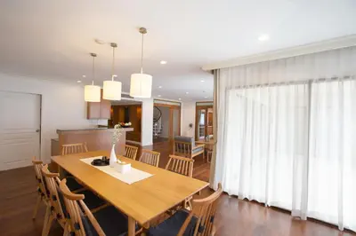 a kitchen and dining room with a wooden table and chairs at Baan Sawasdee Residence in Bangkok