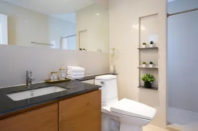 a bathroom with a toilet and a sink and a mirror at Baan Sawasdee Residence in Bangkok