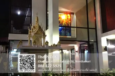 a building with a clock on the side of it at The PaTriX Chaengwattana in Nonthaburi