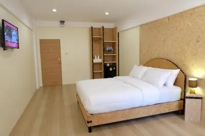 a bedroom with a white bed and a television at Area 69 (Don Muang Airport) in Bangkok